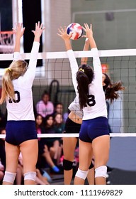 Girl Volleyball player spiking and blocking the ball during a game