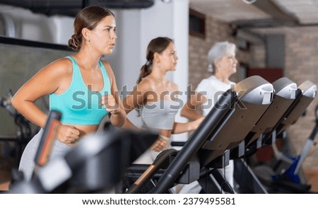 Girl walk on surface of treadmill. Challenge is 10,000 steps per day. Training of respiratory and cardiovascular system, increasing endurance. Electronic tracking for most productive workout