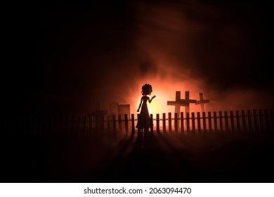 Girl Walking Alone In The Cemetery At Night. Dark Toned Foggy Background. Horror Halloween Concept. Creative Artwork Decoration