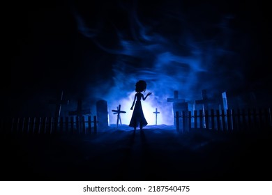 Girl Walking Alone In The Cemetery At Night. Dark Toned Foggy Background. Horror Halloween Concept. Creative Artwork Decoration