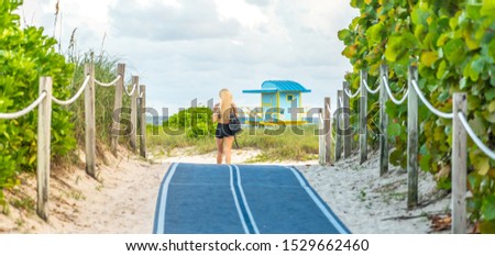 Girl walking to the beach on Footpath. South Beach in Miami, Florida, USA