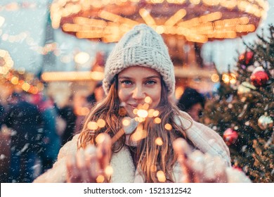 Girl walking in Christmas market decorated with holiday lights in the evening. Feeling happy in big city. Spending winter vacations in Red square, Moscow, Russia.