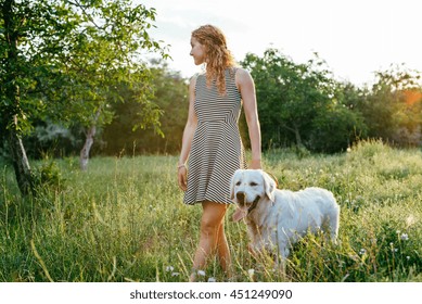 girl walking dog in park
