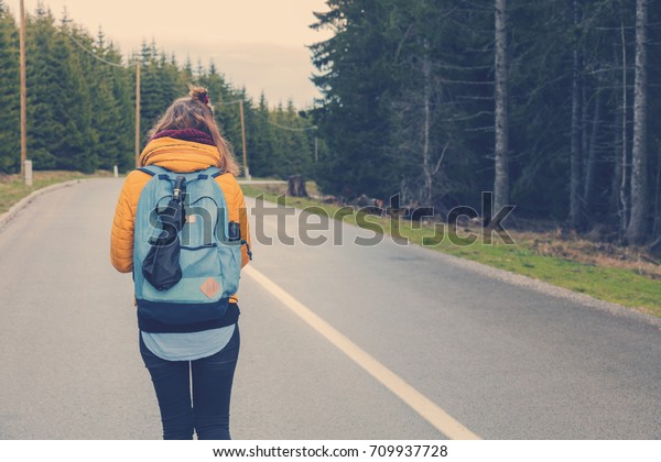 Girl walking down the\
empty suburb road.