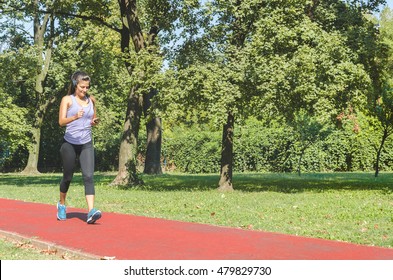 Girl Walking Fast On The Track Running And Listening To Music