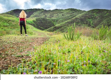 Girl Walking Up Green Hill Where Southern California Wildfire Burned Earlier In The Yard. 