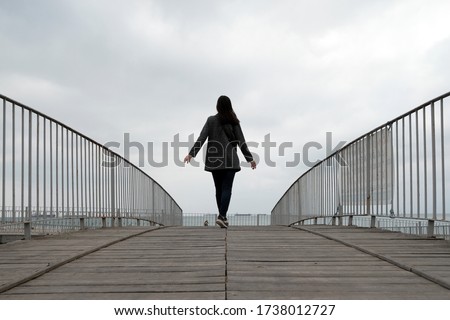 Girl walking on bridge near seaside in istanbul. Perspective view. Marmara seaside. Autumn time. 
