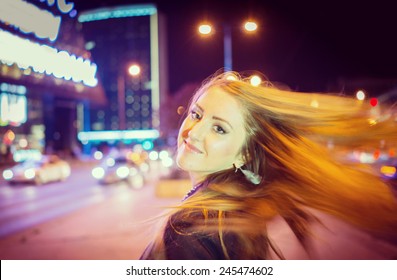 Girl Walking On The Night City Street In Slow Motion (Note: This Image Is In Motion, Without Still Focus)