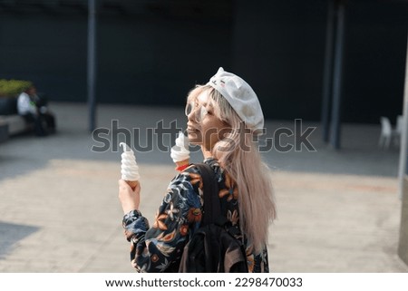 Girl walking on the street with two ice creams 
