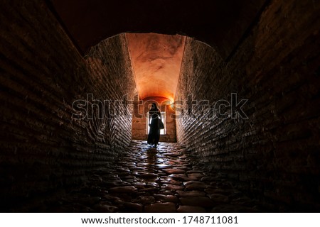 girl walking in a tunnel with a window in the background. Long tunnel. death