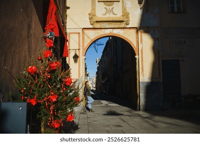 A girl walks along the road of a European city on Christmas Day. A narrow street. Sunset. She has long blonde hair, street casual style. Jeans, scarf and hood - Powered by Shutterstock