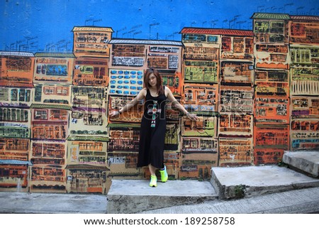 Girl walks around the shopping street with the colorful painting Street Art Graham Street in hong kong