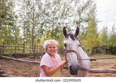 A Girl Walks With A Horse On A Warm Summer Day. 