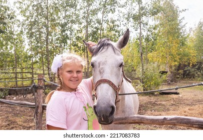 A Girl Walks With A Horse On A Warm Summer Day. 