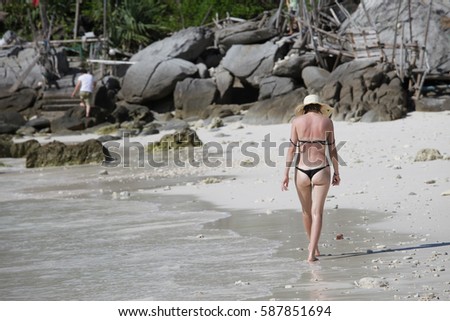 The girl walks on the beach in Phuket, Thailand.
