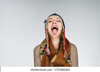 The Girl In A Warm Hat And A Warm Scarf Threw Back Her Head And Stuck Out Her Tongue With A Cheerful Smile