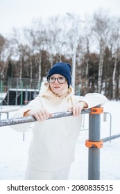 Girl in   warm sports uniform training in   winter park. 