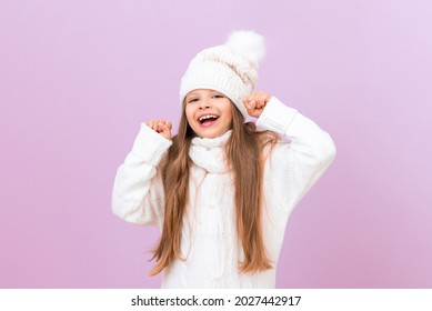 A girl in a warm winter sweater is very happy and smiles.