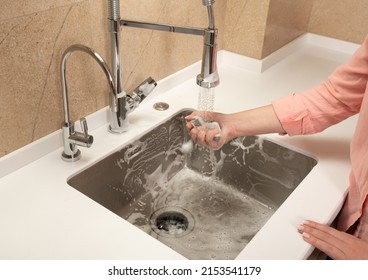 The Girl Washes Away The Foam In The Kitchen Sink From The Sprayer Faucet