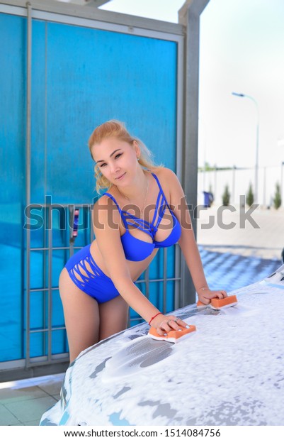The girl washes the\
car at the car wash