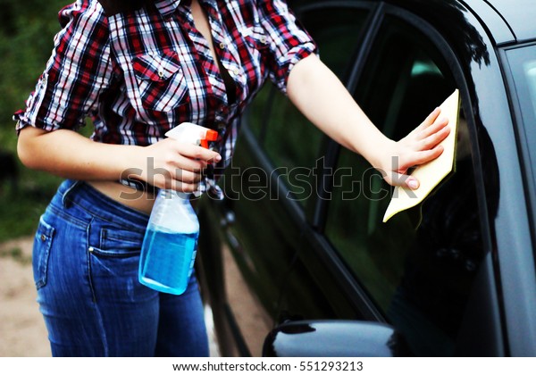 The girl washes the car
window