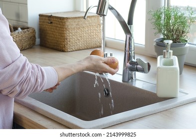 The Girl Washes Eggs Under Running Water. Fight Against Salmonella. Hygiene And Cleanliness In The Kitchen.