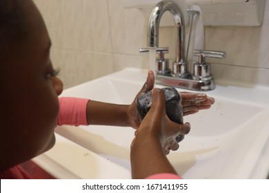 Girl Washing Hands With Black Soap