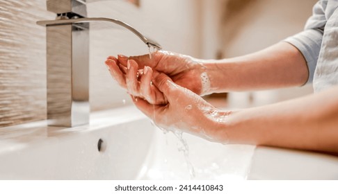 Girl washing hands with soap foam in bathroom with steel faucet. Hygiene and cleaning procedure to prevent virus and desease - Powered by Shutterstock