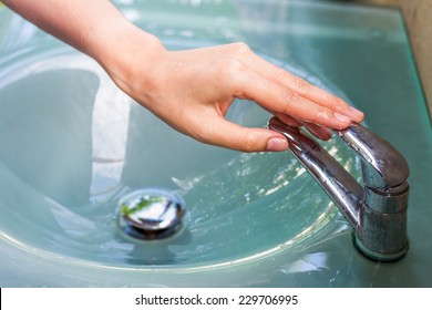 girl washing her hand and turn off faucet out door