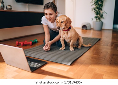 Girl Watching Exercise Tutorials Online With Her Dog