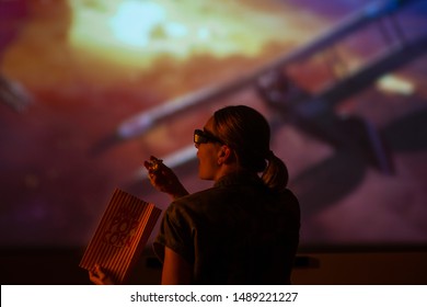 Girl watching a movie in 3D, with glasses on the big screen. with popcorn, entertainment and relaxation. action - Shutterstock ID 1489221227