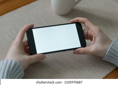 Girl Watching Video Or Play Game On Mobile Phone In Horizontal Position. Isolated Screen For App Mockup, Presentation. Close-up.