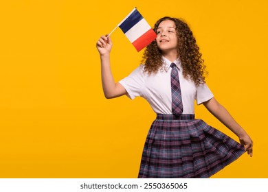 Girl waving French flag playfully in a school uniform. Foreign language learning concept.  - Powered by Shutterstock