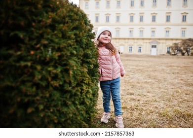 Girl Wear Pink Jacket Stand Near Bush At Valtice Palace, Czech Republic.