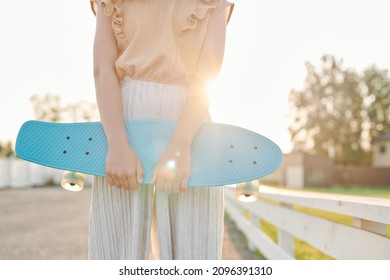 Girl Wear Pleated Pants And A Tulle Bogie Dress Carrying A Sleigh In Front Of The Sunrise In The Barn