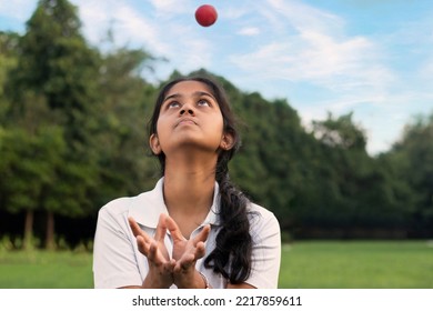 Girl wearing cricket uniform catching the ball on the field - Powered by Shutterstock