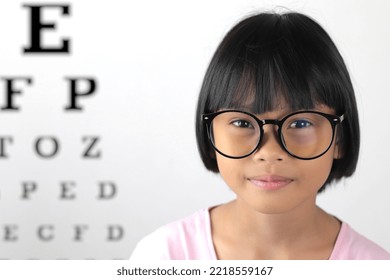 Girl Wearing Glasses And Blurred Eye Chart Background