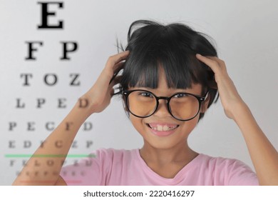 Girl Wearing Glasses And Blurred Eye Chart On Background