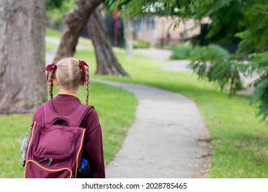 A Girl Wearing Maroon And White School Uniform Walking To School Alone. School Students Return To Classrooms After COVID-19 Outbreak In Australia