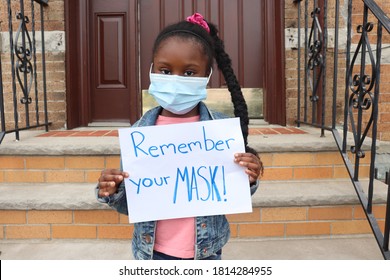 Girl Wearing Mask Near Stairs Holding Sign With Words Remember Your Mask