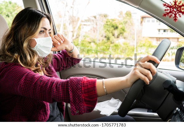 Girl wearing medical mask in the\
car for covid-19. Mask must be put on in everyday\
activities.