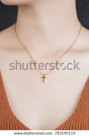 The girl wearing the necklace crosses the neck