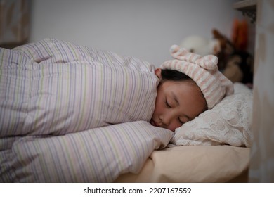 Girl Wearing A Nightcap Sleeping In Bed