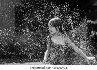 Girl wearing polka dot swim suit in the sprinklers