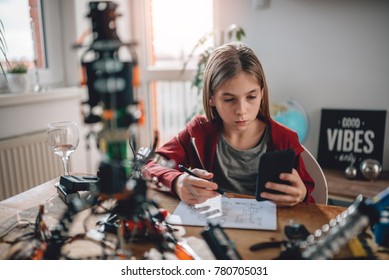 Girl Wearing Red Hoodie Using Smart Phone To Check Electrical Schematic At Home