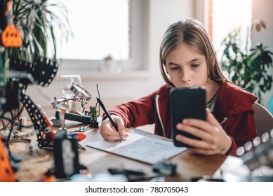  Girl Wearing Red Hoodie Using Smart Phone To Check Electrical Schematic At Home As A School Science Project