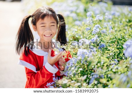The girl wearing the Sandy outfit is smiling, laughing joyfully. Among the flowers