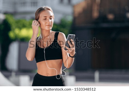 Woman with earphones listening music in smartphone