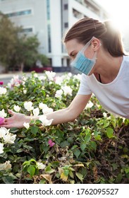 Girl Wearing Surgical Mask Smelling Flowers