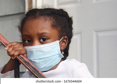 Girl Wearing Surgical Mask Standing On House Back Porch With White Door